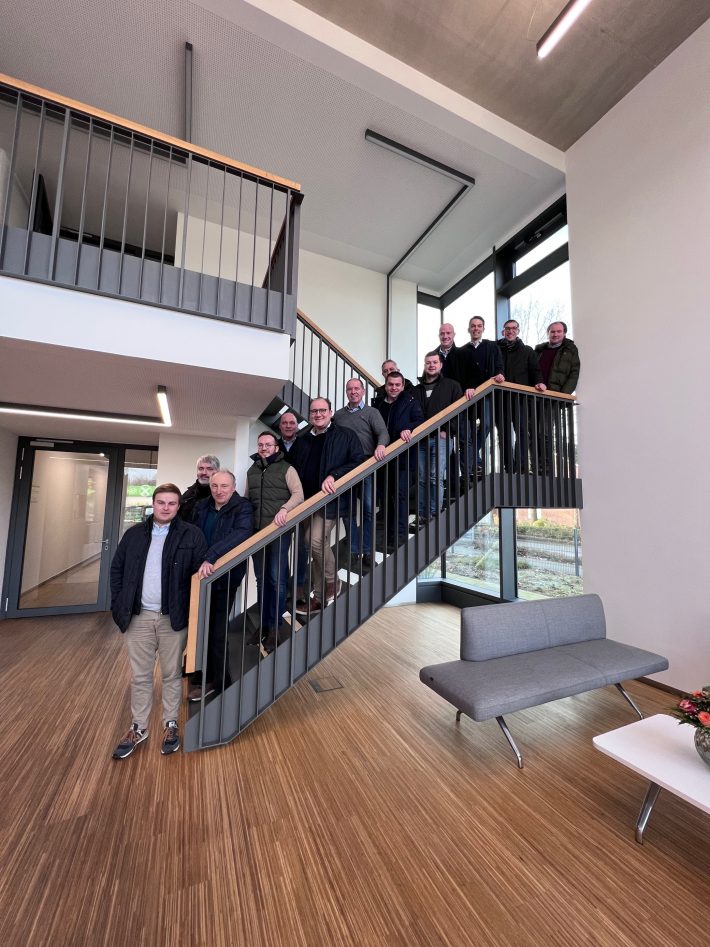 Employees of Westeria and Lybover stand together as a group on the stairs in the Westeria foyer.
